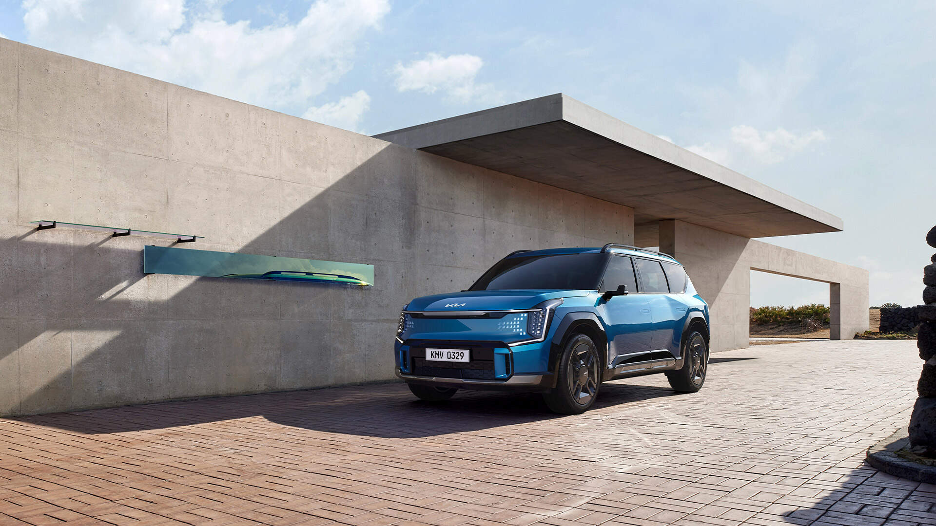 Front side view of Kia EV9 parked in front of a concrete wall
